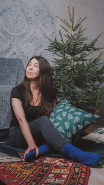 Kız sersem kanepe, rahat bir oda arka planı yakın katta oturuyor. Konsept: romantizm ve rüyalar