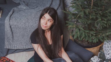 Kız sersem kanepe, rahat bir oda arka planı yakın katta oturuyor. Konsept: romantizm ve rüyalar