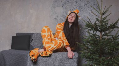 pijama bir zürafa şeklinde. duygusal portre gri bir arka plan bir kız. elbiseli çılgın ve komik adam. temiz cilt ve uzun saç. Çocuk partilerine için animatör