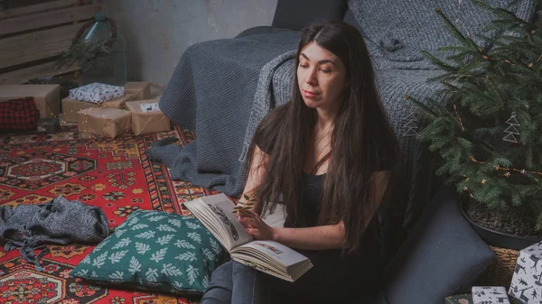 Student reading a book in a cozy room. Girl holding a book. Concept: reading a book