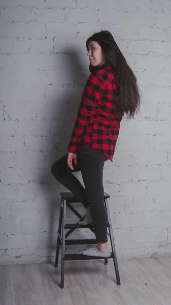 Κορίτσι Κόκκινο Πουκάμισο Μαύρο Καρό Μελαχρινή Ποζάρουν Μια Καρέκλα Ενάντια — Φωτογραφία Αρχείου