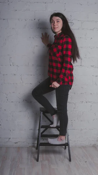 Rapariga Camisa Xadrez Preta Vermelha Morena Posando Com Uma Cadeira — Fotografia de Stock