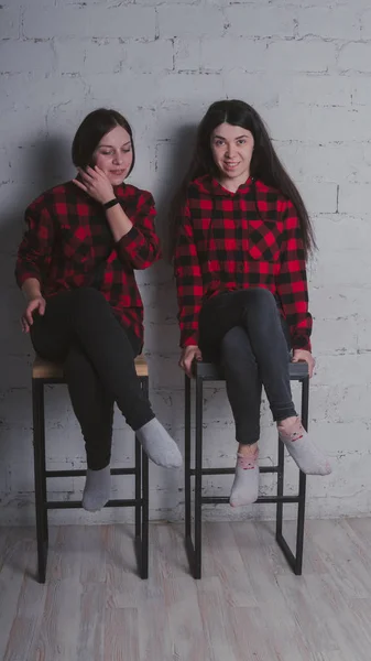 Dos Chicas Jóvenes Camisas Cuadros Rojas Negras Sentadas Sillas Sobre —  Fotos de Stock