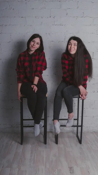 Dos Chicas Jóvenes Camisas Cuadros Rojas Negras Sentadas Sillas Sobre — Foto de Stock