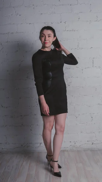 Meisje Poseren Tegen Een Witte Muur Model Zwarte Jurk Brunette — Stockfoto