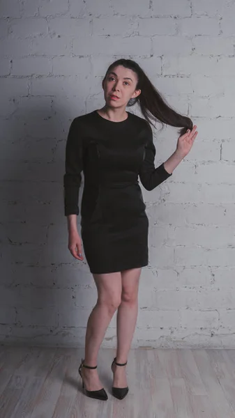 Meisje Poseren Tegen Een Witte Muur Model Zwarte Jurk Brunette — Stockfoto