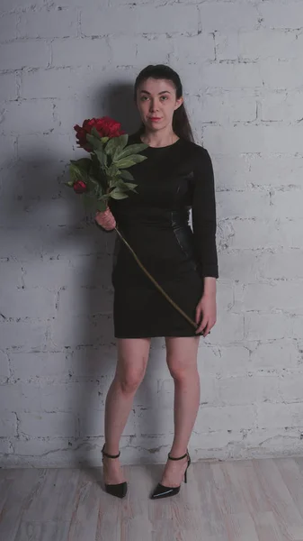 Стройная Девушка Стоит Черном Платье Держа Большой Искусственный Цветок Позируя — стоковое фото