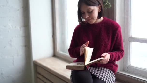 Düşünceli Hayalperest Kız Elinde Kitapla Evde Oturmuş Büyük Pencereye Bakıyor — Stok video