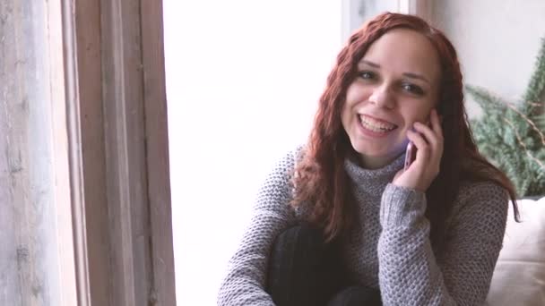 Ładna Dziewczyna Siedzi Parapecie Smartphone Ręce Ona Długie Włosy Uśmiech — Wideo stockowe