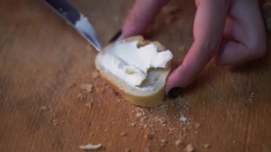 Krem peynirli börek ekmek üzerinde yayılıyor. Ekmek ve tereyağı