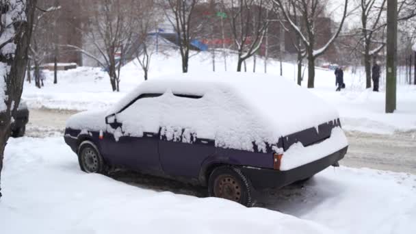 暴风雪过后 一辆汽车的前部被埋在雪中 大雪灾过后被雪覆盖的汽车 — 图库视频影像