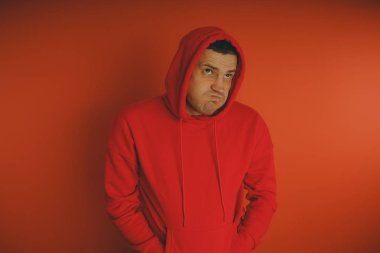 Turuncu bir arka plan üzerinde poz çılgın ve karizmatik adam. Bir erkekte bir kırmızı eşofman.