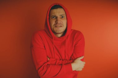 Turuncu bir arka plan üzerinde poz çılgın ve karizmatik adam. Bir erkekte bir kırmızı eşofman.