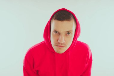 Çılgın ve karizmatik adam kılığında. Bir erkekte bir kırmızı eşofman. Adam beyaz arka plan, metin için yer üzerinde izole