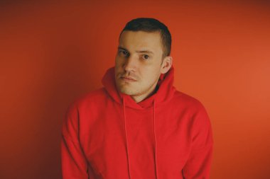 Turuncu bir arka plan üzerinde poz çılgın ve karizmatik adam. Bir erkekte bir kırmızı eşofman.