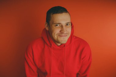 Turuncu bir arka plan üzerinde poz çılgın ve karizmatik adam. Bir erkekte bir kırmızı eşofman.