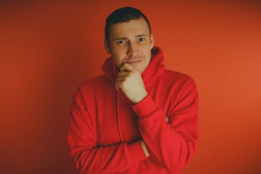 Turuncu bir arka plan üzerinde poz çılgın ve karizmatik adam. Bir erkekte bir kırmızı eşofman.