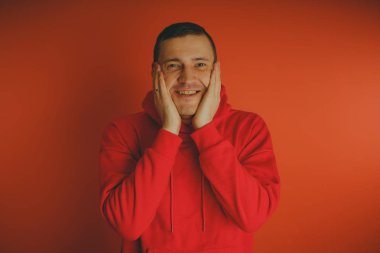 Turuncu bir arka plan üzerinde poz çılgın ve karizmatik adam. Bir erkekte bir kırmızı eşofman.