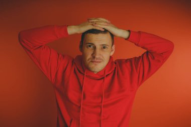 Turuncu bir arka plan üzerinde poz çılgın ve karizmatik adam. Bir erkekte bir kırmızı eşofman.