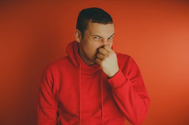 Turuncu bir arka plan üzerinde poz çılgın ve karizmatik adam. Bir erkekte bir kırmızı eşofman.