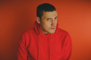 Turuncu bir arka plan üzerinde poz çılgın ve karizmatik adam. Bir erkekte bir kırmızı eşofman.