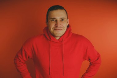 Turuncu bir arka plan üzerinde poz çılgın ve karizmatik adam. Bir erkekte bir kırmızı eşofman.