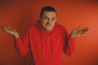 Turuncu bir arka plan üzerinde poz çılgın ve karizmatik adam. Bir erkekte bir kırmızı eşofman.