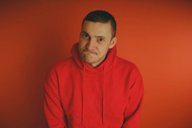 Turuncu bir arka plan üzerinde poz çılgın ve karizmatik adam. Bir erkekte bir kırmızı eşofman.