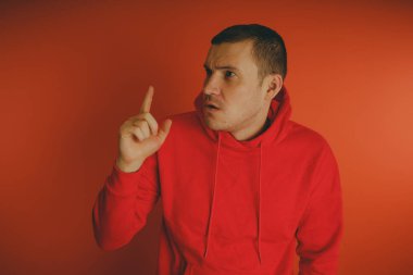 Turuncu bir arka plan üzerinde poz çılgın ve karizmatik adam. Bir erkekte bir kırmızı eşofman.