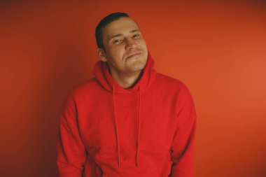 Turuncu bir arka plan üzerinde poz çılgın ve karizmatik adam. Bir erkekte bir kırmızı eşofman.