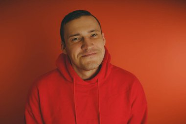 Turuncu bir arka plan üzerinde poz çılgın ve karizmatik adam. Bir erkekte bir kırmızı eşofman.