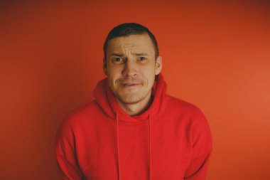 Turuncu bir arka plan üzerinde poz çılgın ve karizmatik adam. Bir erkekte bir kırmızı eşofman.