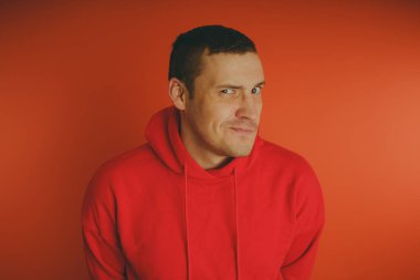 Turuncu bir arka plan üzerinde poz çılgın ve karizmatik adam. Bir erkekte bir kırmızı eşofman.