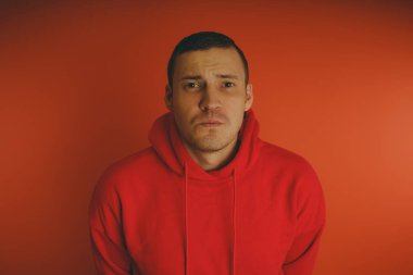 Turuncu bir arka plan üzerinde poz çılgın ve karizmatik adam. Bir erkekte bir kırmızı eşofman.