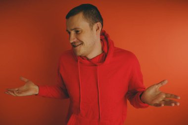 Turuncu bir arka plan üzerinde poz çılgın ve karizmatik adam. Bir erkekte bir kırmızı eşofman.