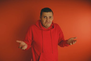 Turuncu bir arka plan üzerinde poz çılgın ve karizmatik adam. Bir erkekte bir kırmızı eşofman.