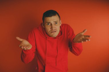 Turuncu bir arka plan üzerinde poz çılgın ve karizmatik adam. Bir erkekte bir kırmızı eşofman.