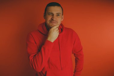 Turuncu bir arka plan üzerinde poz çılgın ve karizmatik adam. Bir erkekte bir kırmızı eşofman.