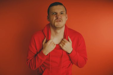 Turuncu bir arka plan üzerinde poz çılgın ve karizmatik adam. Bir erkekte bir kırmızı eşofman.