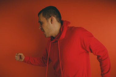 Turuncu bir arka plan üzerinde poz çılgın ve karizmatik adam. Bir erkekte bir kırmızı eşofman.