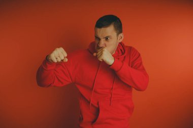 Turuncu bir arka plan üzerinde poz çılgın ve karizmatik adam. Bir erkekte bir kırmızı eşofman.