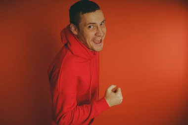 Turuncu bir arka plan üzerinde poz çılgın ve karizmatik adam. Bir erkekte bir kırmızı eşofman.