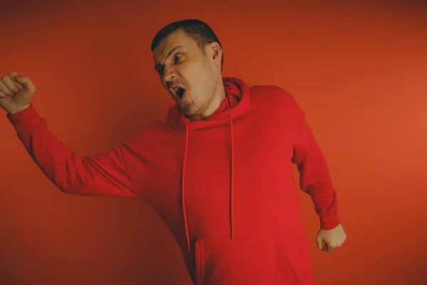 Őrült Karizmatikus Srác Pózol Narancssárga Háttérrel Férfi Egy Piros Melegítőben — Stock Fotó