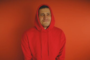 Turuncu bir arka plan üzerinde poz çılgın ve karizmatik adam. Bir erkekte bir kırmızı eşofman.