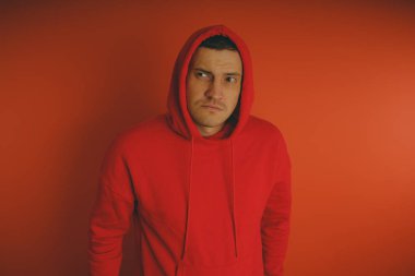 Turuncu bir arka plan üzerinde poz çılgın ve karizmatik adam. Bir erkekte bir kırmızı eşofman.