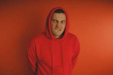 Turuncu bir arka plan üzerinde poz çılgın ve karizmatik adam. Bir erkekte bir kırmızı eşofman.