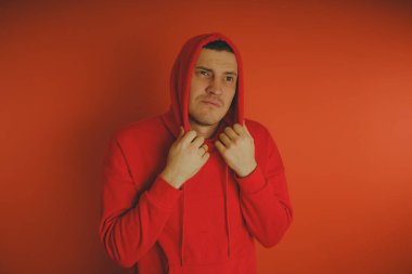 Turuncu bir arka plan üzerinde poz çılgın ve karizmatik adam. Bir erkekte bir kırmızı eşofman.