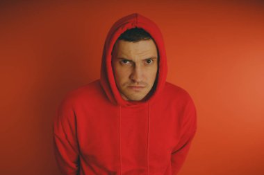 Turuncu bir arka plan üzerinde poz çılgın ve karizmatik adam. Bir erkekte bir kırmızı eşofman.