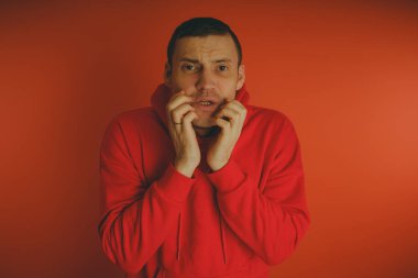 Turuncu bir arka plan üzerinde poz çılgın ve karizmatik adam. Bir erkekte bir kırmızı eşofman.