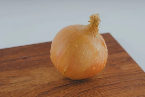 木の板 白い背景の上に新鮮な玉ねぎ 健康ダイエットのための野菜 玉ねぎは ビタミン 便利に富んでいます 木製の背景にタマネギの皮 ヘルシーなサラダのための成分 — ストック写真